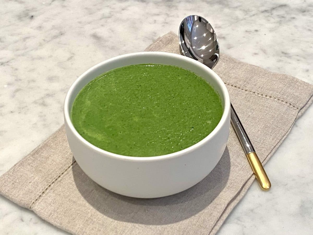 A bowl of gorgeous green soup that is packed with ingredients to make you happy.