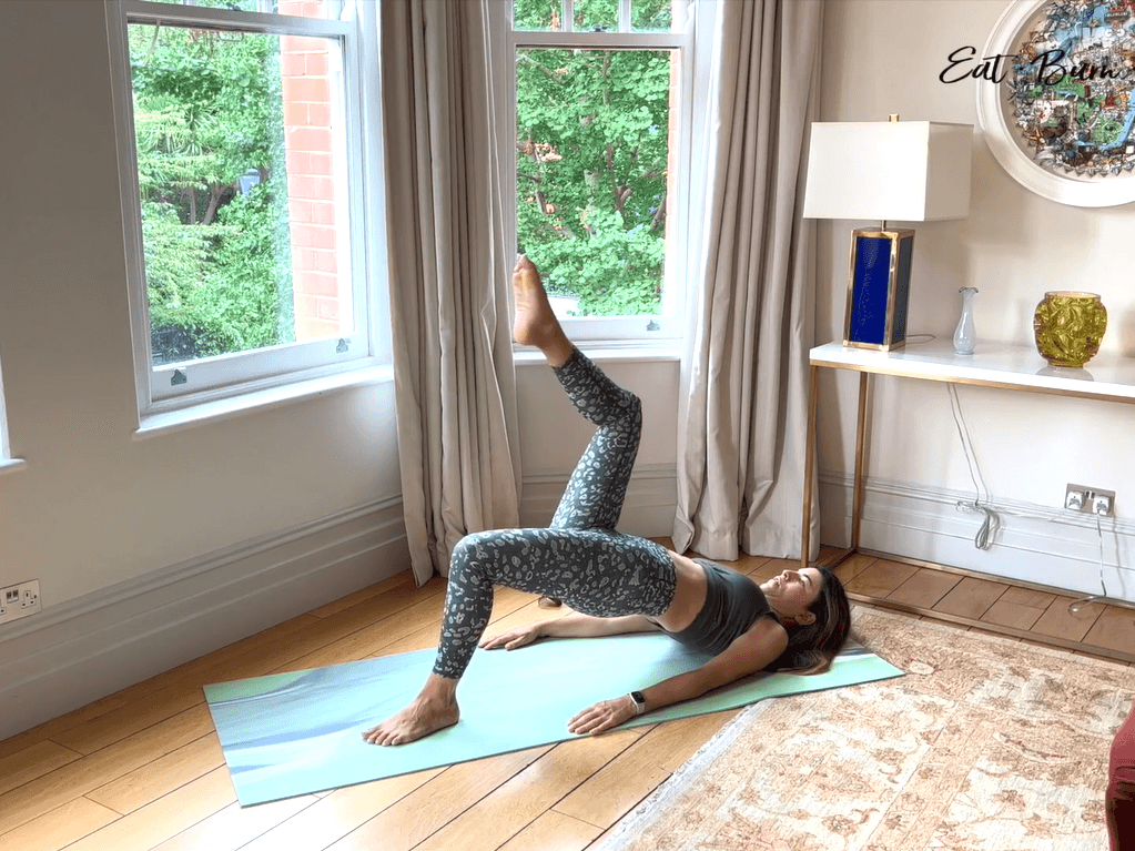 Yalda Alaoui on her exercise mat, mid-exercise, with her leg in the air.