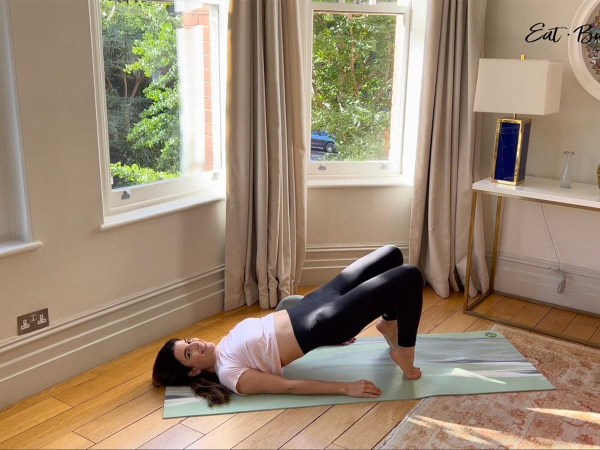 Woman lying on her back in a bridge pose on her toes