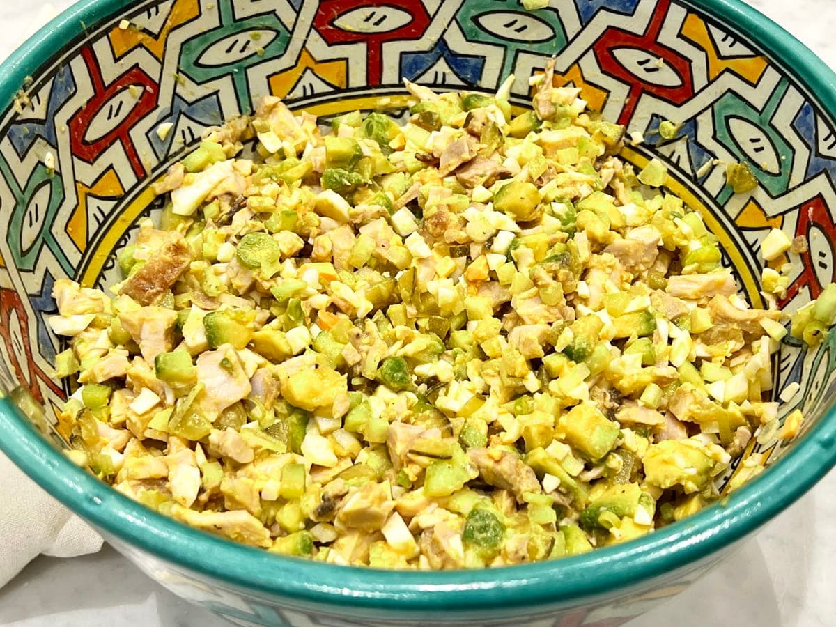 bowl of chicken salad with spring onions and avocado